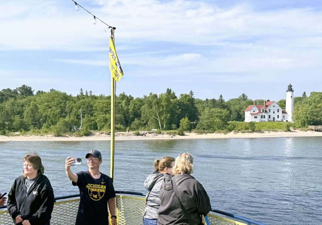 boat tour in front of light house